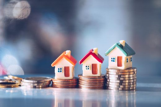 maisons miniatures sur tas de pièces de monnaie