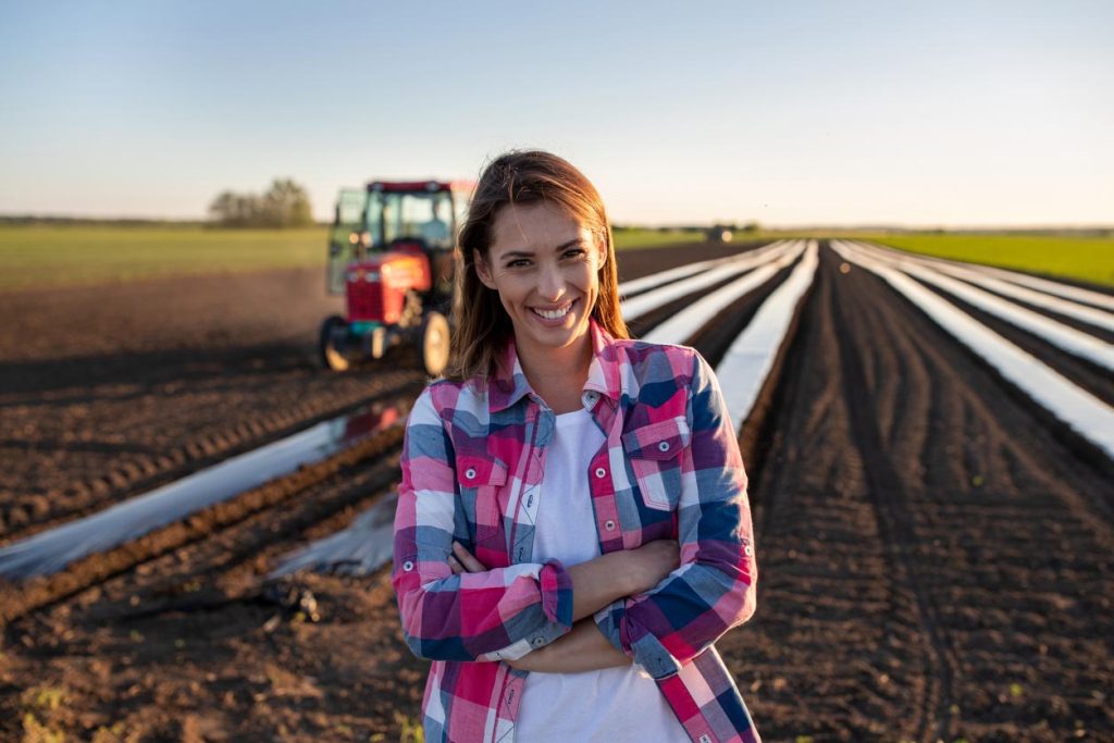 Agricultrice debout les bras croisés dans le champ