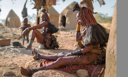 Femmes Himba Assises Devant Leurs Huttes Dans Un Village Traditionnel Près De Kamanjab, Namibie, Afrique
