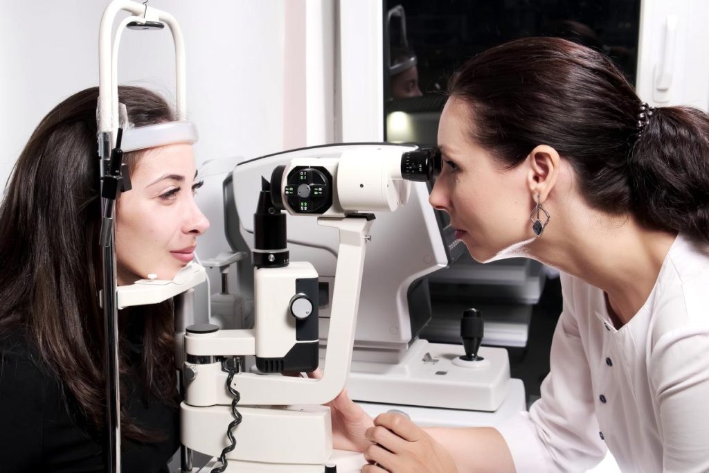 Ophtalmologue observe les yeux d'une patiente