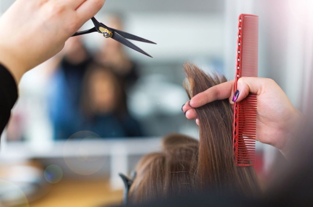 Mains De Coiffeur Avec Ciseaux Et Peigne Coiffe Une Femme